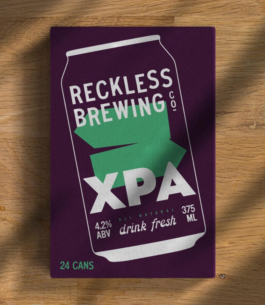 Reckless XPA beer carton sitting on wooden background