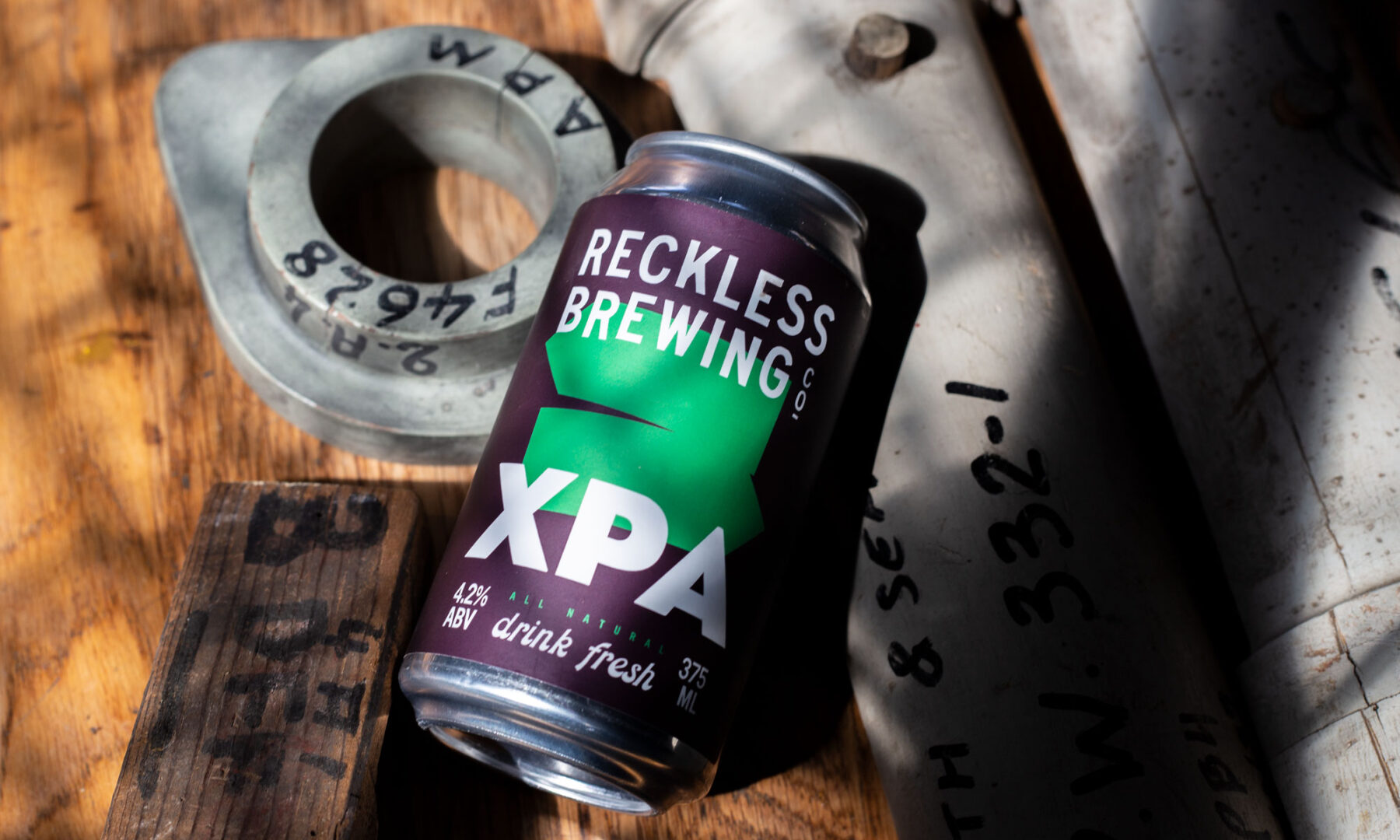 Reckless Brewing XPA beer can on industrial background